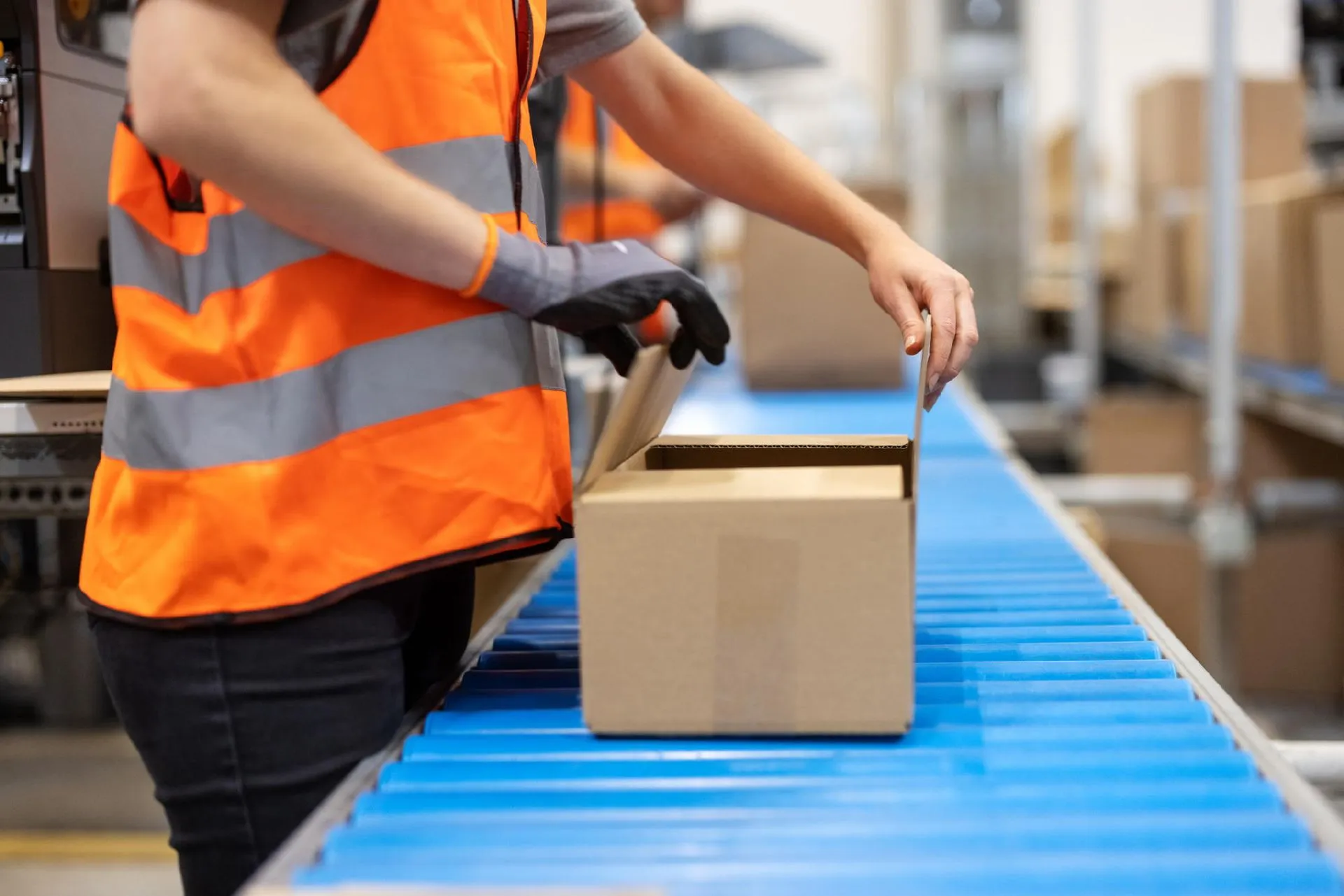 Operatore durante l’imballaggio su linea di produzione industriale
