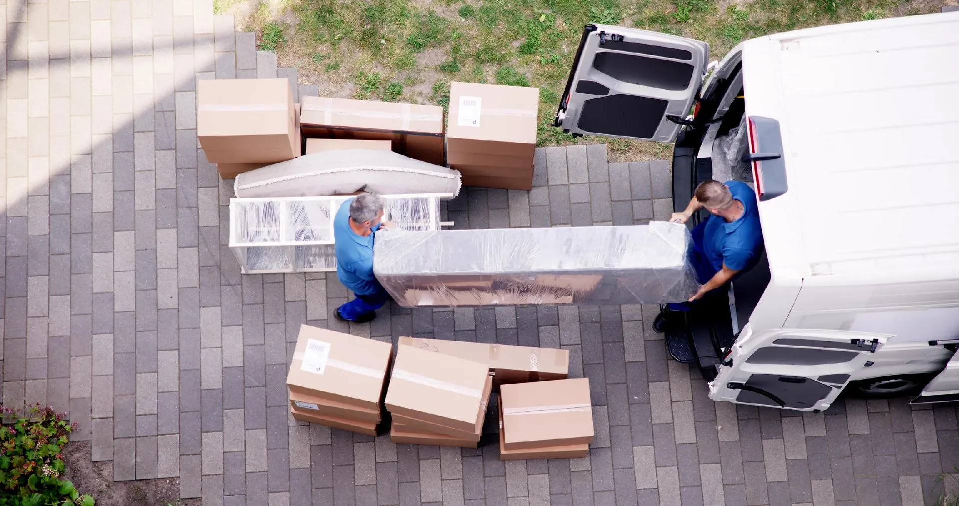 Facchini mentre caricano scatole su un furgone per servizio di logistica urbana