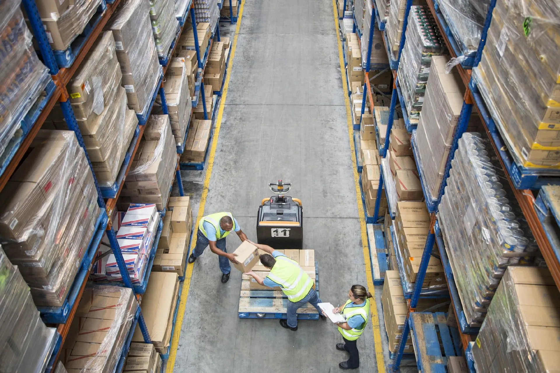 Operatori di facchinaggio al lavoro nella logistica di magazzino con movimentazione pallet