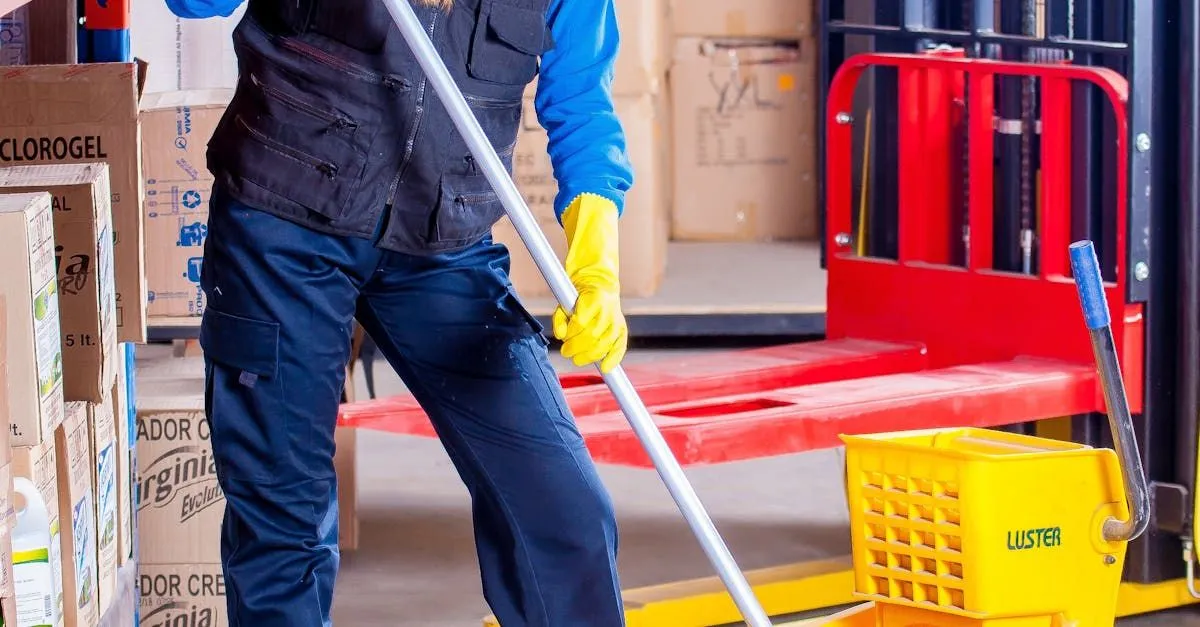 Addetto alla pulizia industriale mentre lava i pavimenti con mop professionale in ambiente produttivo
